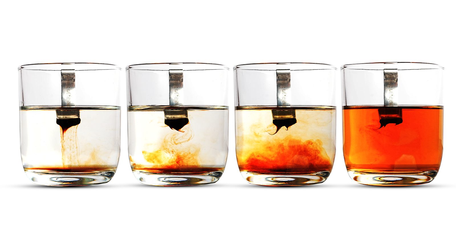 Four glasses showing shilajit resin dissolving fully in warm water over time